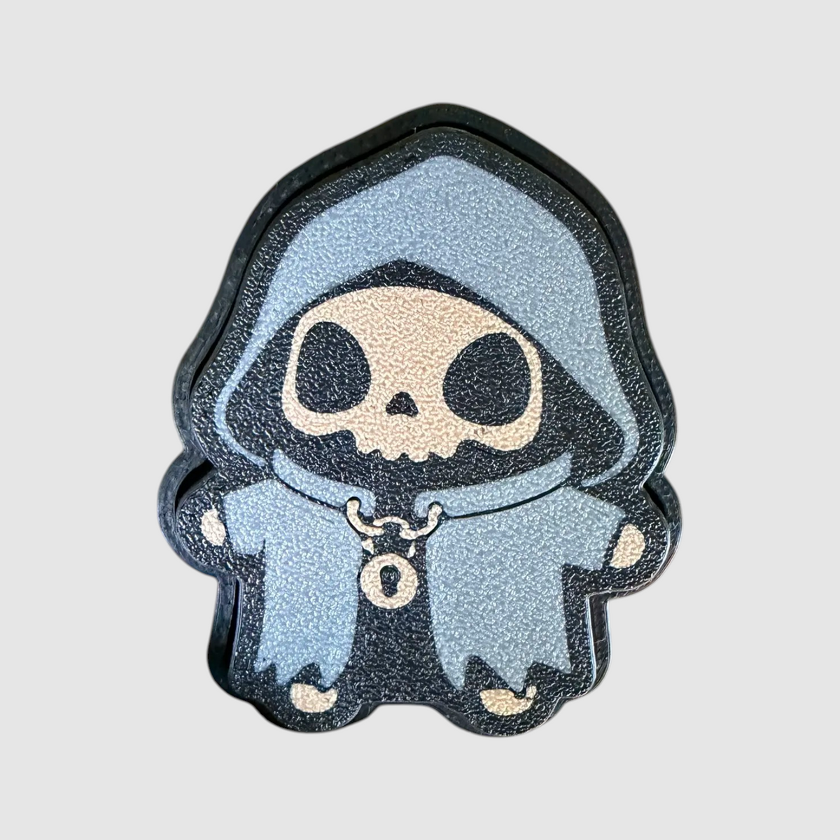 Grim 3D printed clicker on grey